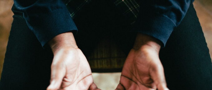 person showing both palms while sitting on chair